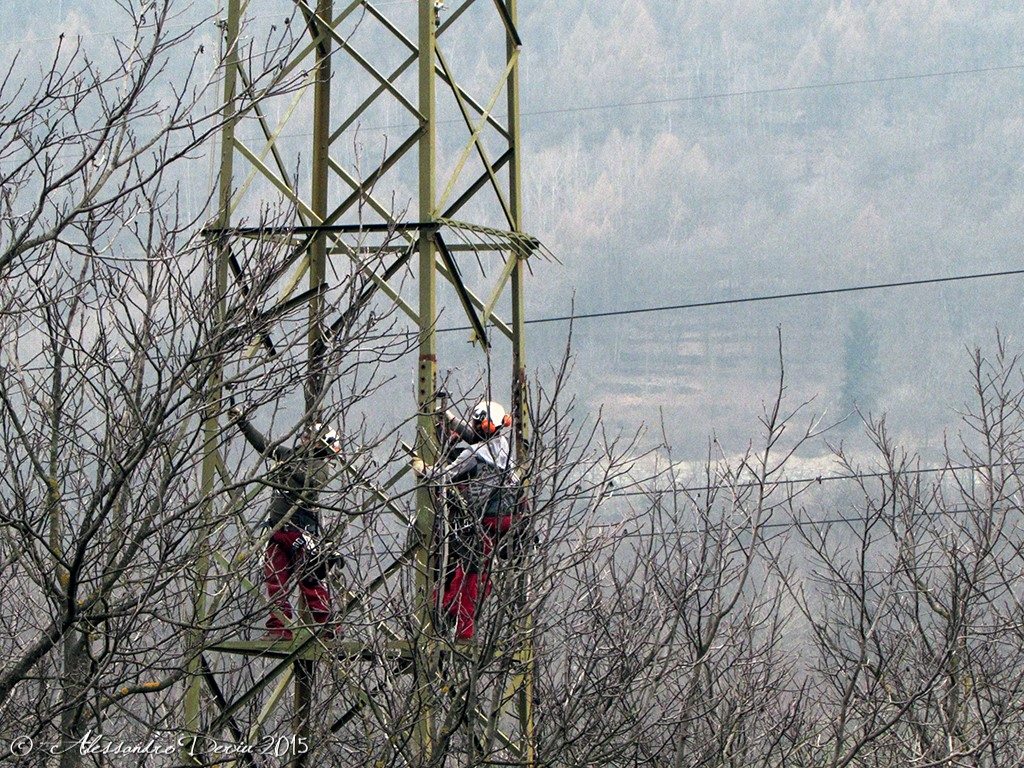 Operai al lavoro su tralicci della corrente elettrica in Valtellina